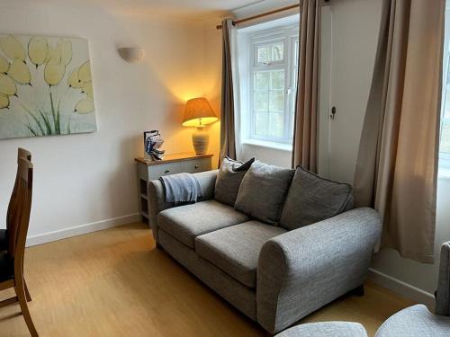 a living room with a couch and a window at 10 Wye Rapids Cottages in Symonds Yat