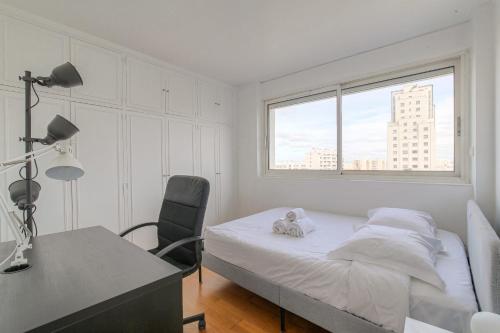 une chambre avec un lit, un bureau et une fenêtre dans l'établissement Lumineux et Calme avec parking gratuit, à Villeurbanne