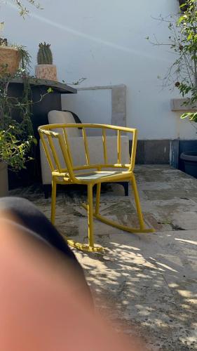 a yellow bench sitting in the middle of a yard at Hotel del europe in Tel Aviv
