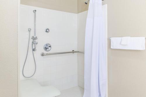 uma casa de banho com um chuveiro e uma cortina de chuveiro branca. em SpringHill Suites by Marriott Houston Brookhollow em Houston
