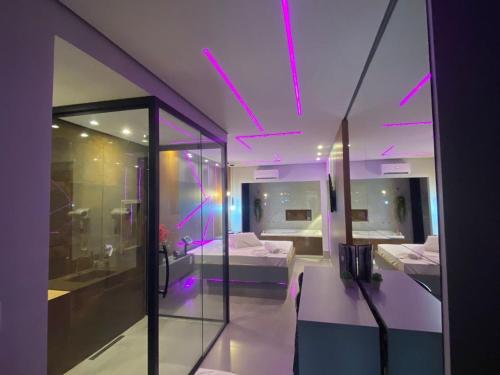 Zimmer mit 2 Betten und einem Zimmer mit violetten Lichtern in der Unterkunft Up Motel in Ribeirão Preto