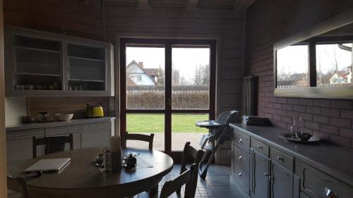 a kitchen with a table and a table and a window at Haus am Meer in Dębki