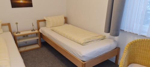 a small bedroom with a small bed with a yellow blanket at Ferienhaus Pauls Ferienhaus Pauls, Whg 01 in Norderney