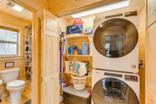 a tiny house bathroom with a washer and dryer at Secluded Murphy Cabin Rental with Deck and Fire Pit! in Turtletown