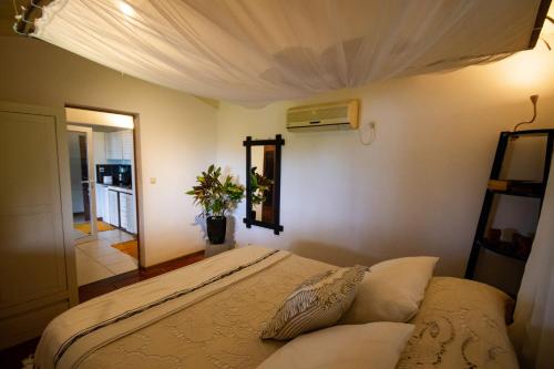 a bedroom with a bed with a ceiling at MADIROKELY HOUSE Nosy Be in Ambatoloaka