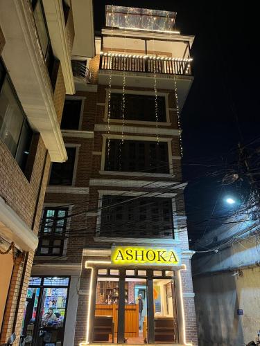een winkel met een bord voor een gebouw bij Ashoka home in Pātan