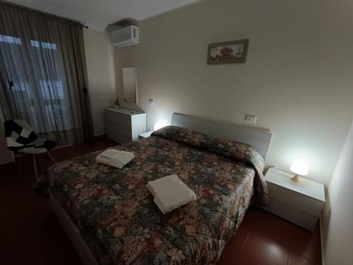 a bedroom with a bed with two towels on it at La Casetta per te in Gravina di Catania