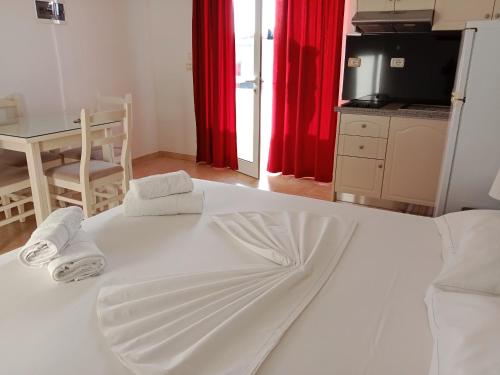 a large white bed in a room with a table at Hotel Villa Ruci in Ksamil