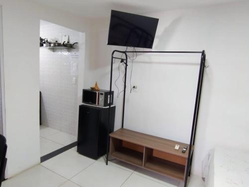 a room with a mirror and a tv on top at KITNET EM OLINDA CASA CAIADA A 50 MT DA PRAIA in Olinda