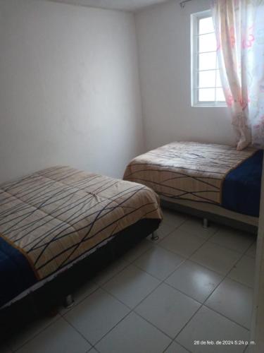 a bedroom with two beds and a window at hermoso departamento un lugar para descansar 2 in Tlaxcala de Xicohténcatl