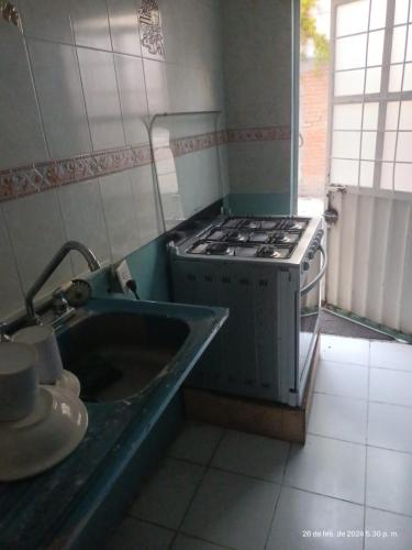 a kitchen with a stove and a sink at hermoso departamento un lugar para descansar 2 in Tlaxcala de Xicohténcatl