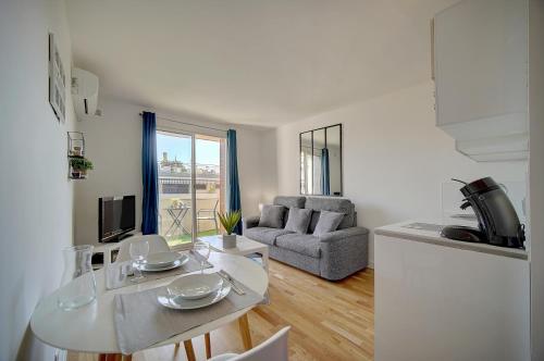 une cuisine et un salon avec une table et des chaises dans l'établissement Le Palm - 100m Plage - Croisette - Verrière Côte d’Azur, à Cannes