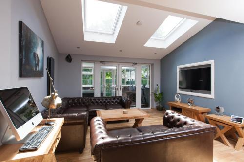 a living room with a couch and a tv at Luxe Arthurs Seat View Townhouse with Hot Tub in Edinburgh