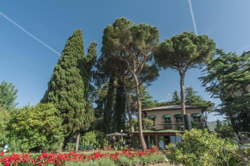 a house in the midst of trees and flowers at Hotel Kursaal in Passignano sul Trasimeno
