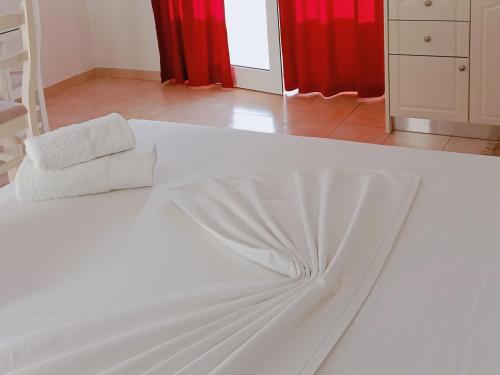 a white bed with two towels on top of it at Hotel Villa Ruci in Ksamil