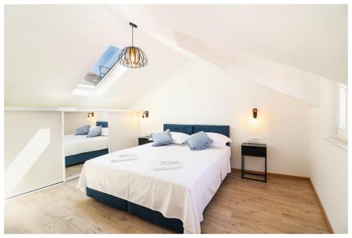a bedroom with a large white bed with blue pillows at House Gambin in Primošten