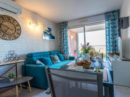 un salon avec un canapé bleu et une table dans l'établissement Apartment Les Colonnes de Circé by Interhome, au Cap d'Agde