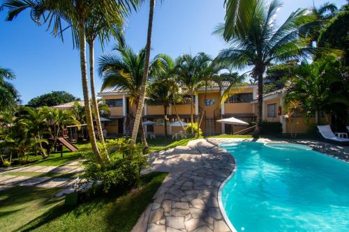 uma vista para um resort com uma piscina e palmeiras em Hotel Latitud Buzios by Latitud Hoteles em Búzios
