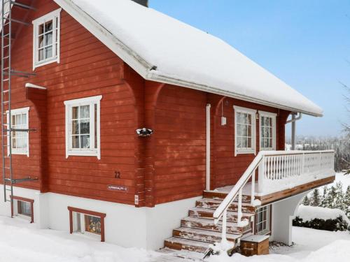 una casa roja con nieve en las escaleras en Holiday Home Aurinkoalppi 12b paritalo by Interhome, en Hyrynsalmi