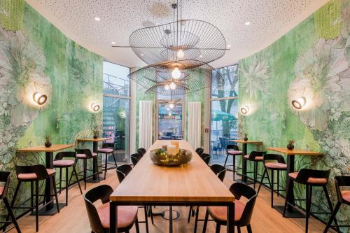 a restaurant with tables and chairs in a room with green walls at KOOS Hotel&Apartments - City Aparthotel in Munich