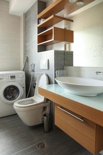 a bathroom with a toilet and a sink and a washing machine at VIP Apartments in Sarajevo