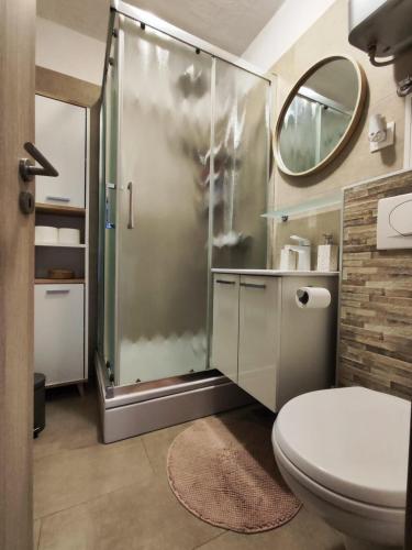uma casa de banho com um chuveiro e um WC. em My happy place em Poreč