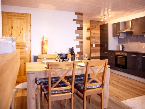 uma cozinha com uma mesa de madeira e 2 cadeiras em Apartment Les Chavonnes by Interhome em Gryon