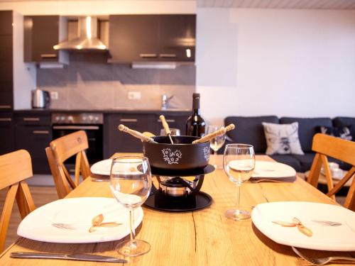a table with glasses and a pot of wine on it at Apartment Chavonnes 11 by Interhome in Gryon