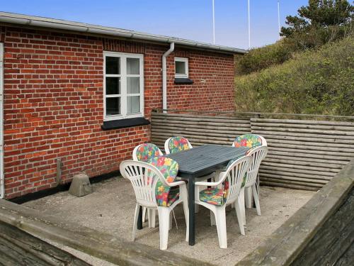 a table and four chairs in front of a brick building at Apartment Withar - all inclusive - 800m from the sea by Interhome in Fanø
