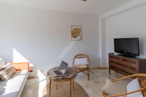 Una sala de estar con un sofá y un televisor. en TrendyHomes San Sebastián, en Almería