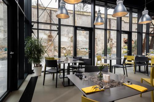 um restaurante com mesas e cadeiras e janelas grandes em Hotel VP1 em Ostrava