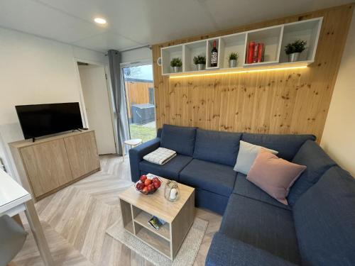 a living room with a blue couch and a tv at Holiday Home Villa Ramses by Interhome in Riedenburg