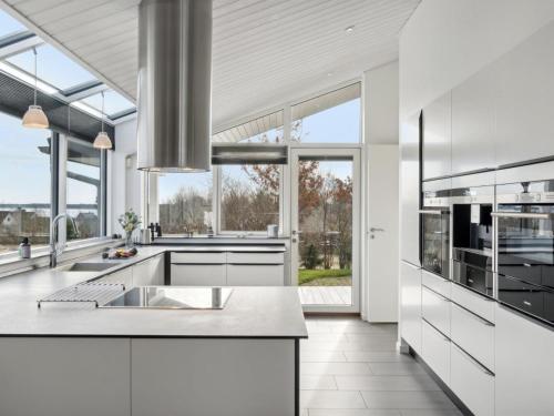 uma cozinha com bancadas brancas e janelas grandes em Holiday Home Yall - all inclusive - 175m from the sea by Interhome em Nyrup