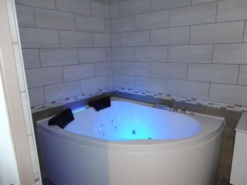 La salle de bains est pourvue d'une grande baignoire et d'un mur carrelé. dans l'établissement les sapins appartement 4**** 6/8personnes,sauna,parking privé, à Gérardmer