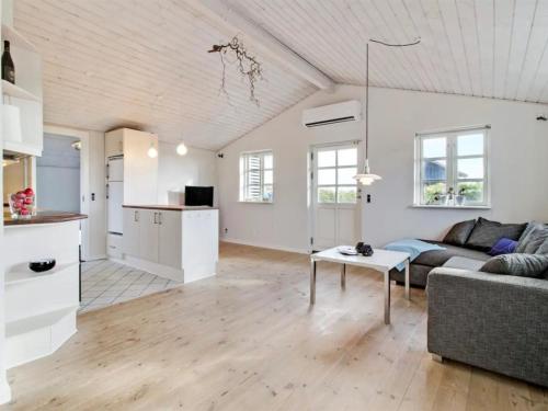 een woonkamer met een bank en een tafel bij Holiday Home Baarde - all inclusive - 60m from the sea by Interhome in Grenå