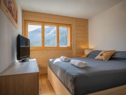 Schlafzimmer mit einem Bett und einem Flachbild-TV in der Unterkunft Apartment L' O 12 by Interhome in Ovronnaz