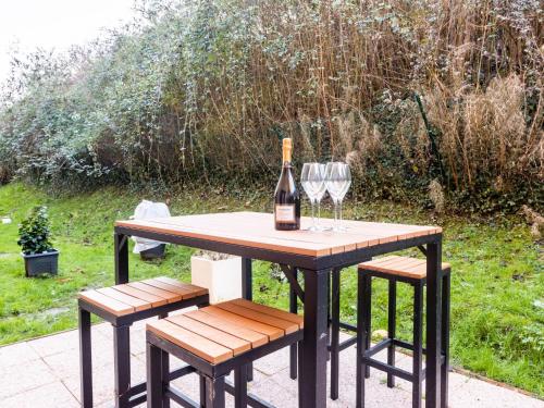 - une table avec une bouteille de vin et 2 verres à vin dans l'établissement Apartment Le Hameau du prieuré by Interhome, à Bonneville-sur-Touques