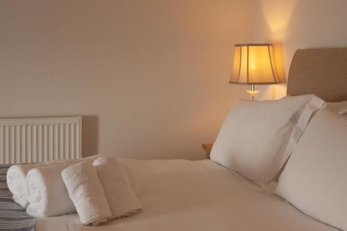 a bedroom with two white towels on a bed at Cottages at the Lugger in Portloe