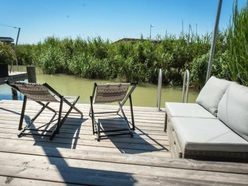 a couple of chairs and a couch on a dock at Holiday Home Relax Lodge am See by Interhome in Neusiedl am See