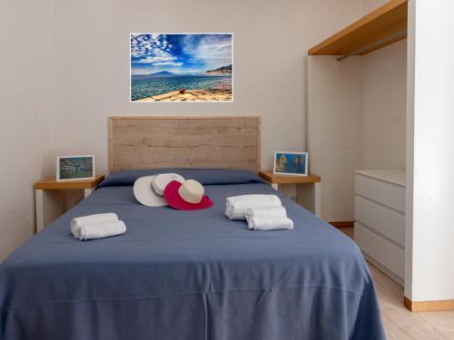 een slaapkamer met een blauw bed met 2 kussens bij Apartment Freedom Relais Club-6 by Interhome in Massa Lubrense