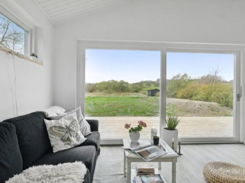 ein Wohnzimmer mit einem Sofa und einem großen Fenster in der Unterkunft Holiday Home Sys - all inclusive - 150m from the sea by Interhome in Knebel