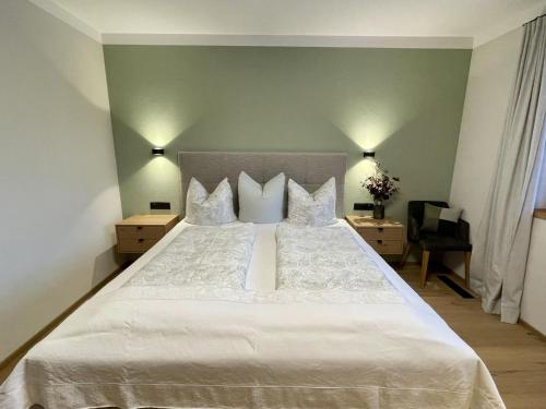 um quarto com uma grande cama branca com almofadas em Apartment Holzerjuwel by Interhome em Oberau