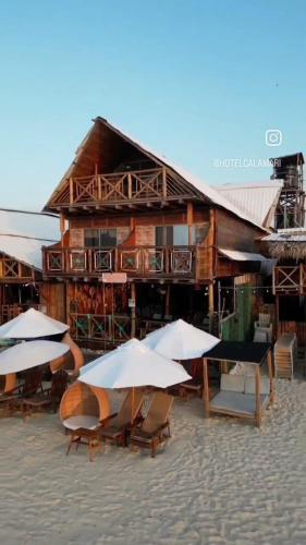 a group of tables and umbrellas in front of a building at Hotel Calamari Baru in Playa Blanca
