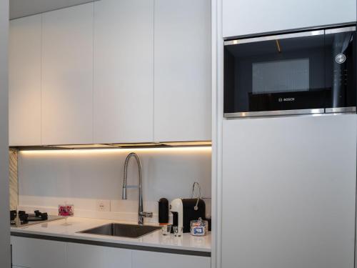 ロゼート・デッリ・アブルッツィにあるApartment Mar di Roseto by Interhomeのシンクと電子レンジを備えた白いキッチン