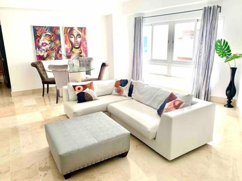 ein Wohnzimmer mit einem weißen Sofa und einem Tisch in der Unterkunft SUPER Spacious Modern Relax/CiPLA/CECiLIP in Santo Domingo