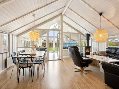 een eetkamer en een woonkamer met een tafel en stoelen bij Holiday Home Chrisse - all inclusive - 250m from the sea by Interhome in Otterup