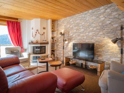 a living room with a couch and a tv at Apartment Caroubier 6 by Interhome in Ovronnaz