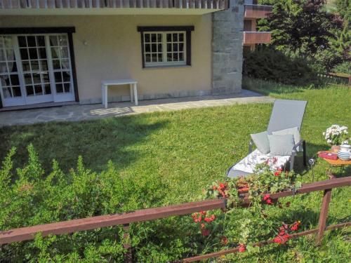 un giardino con una sedia e un tavolo di fronte a una casa di Apartment Bernasconi Garden Flat by Interhome a Madesimo