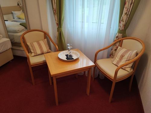 福爾巴克的住宿－Room in Guest room - Pension Forelle - Doppelzimmer，一间设有两把椅子、一张桌子和一张床的房间
