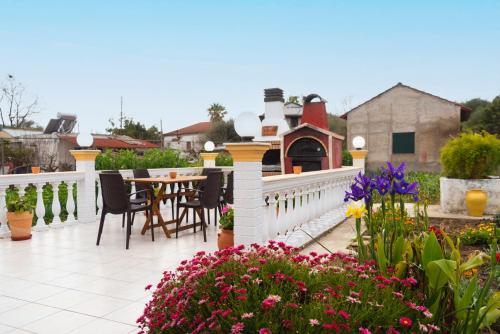 a patio with a table and chairs and flowers at Loutra Holiday House in Petrití